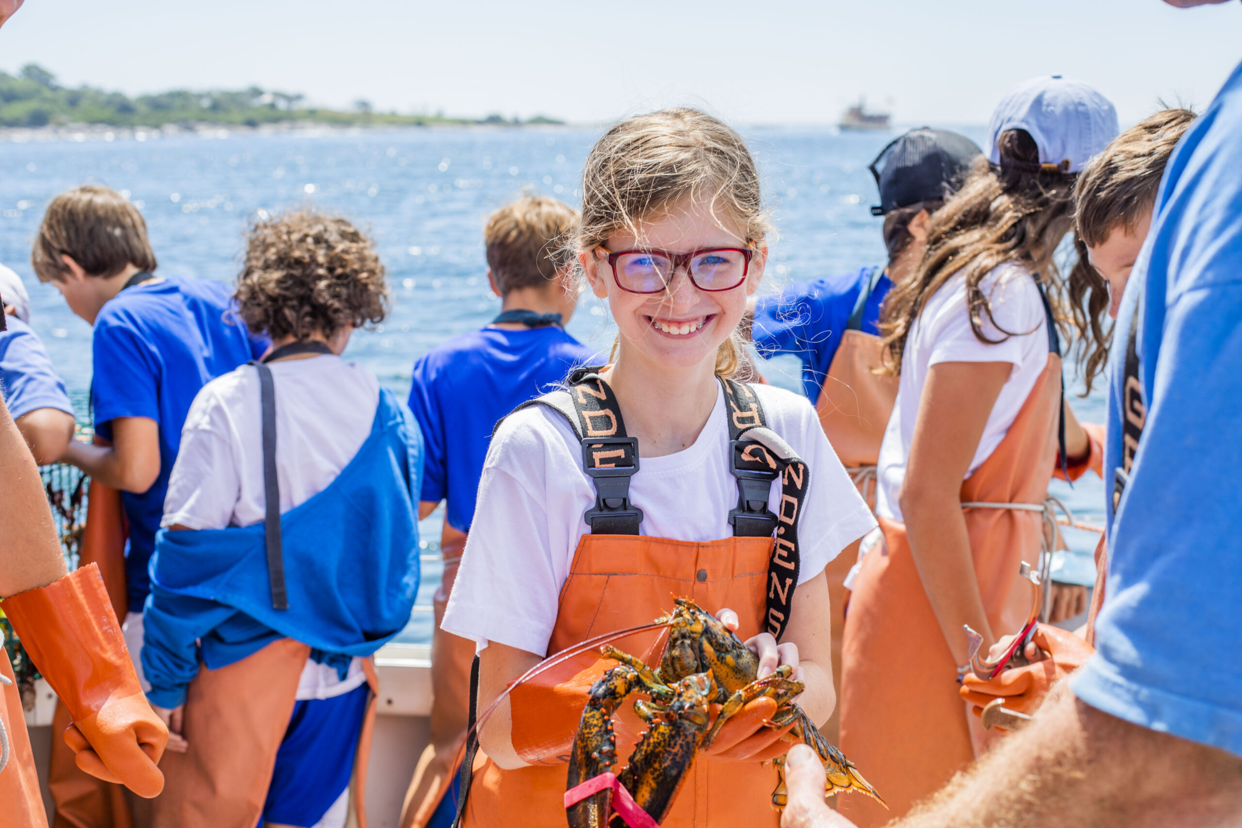 Campers experiencing Maine traditions like lobster fishing on a weekly nature trip with Kamp Kohut.