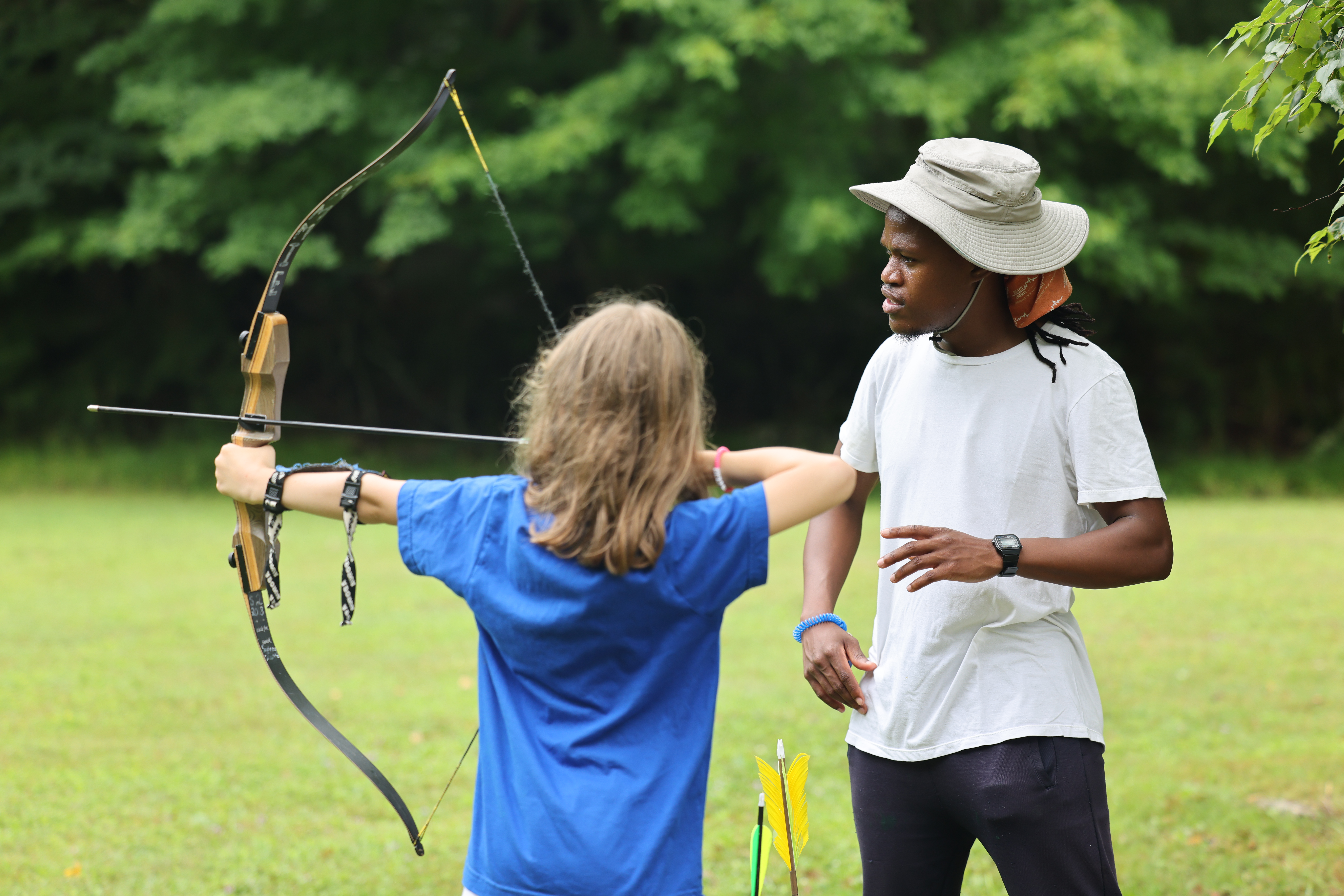 Camper receiving expert archery instruction at Kamp Kohut, a sleepaway summer camp in Oxford, Maine.